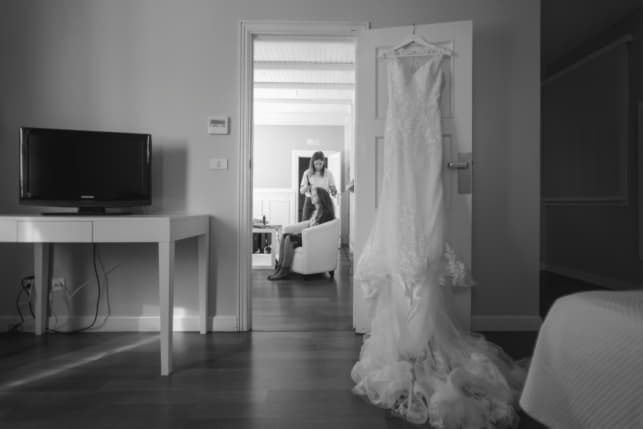 Fotografía de la habitación de la novia donde se le ve peinando a la novia